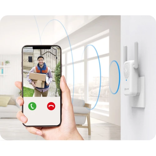 Osoba trzyma smartfon z aplikacją do wideorozmów, pokazującą dostawcę z paczką. Obok na ścianie zamontowany jest biały dzwonek wewnętrzny z antenami, emitujący sygnał dźwiękowy.