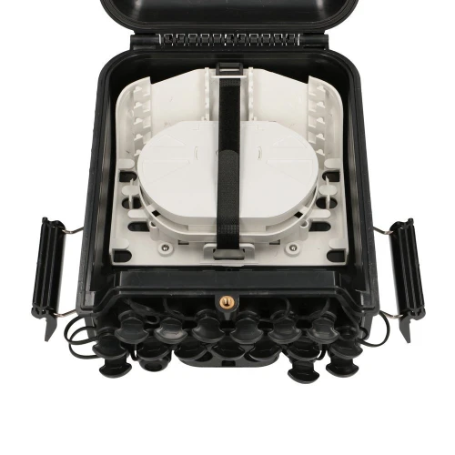 Na zdjęciu znajduje się czarna, otwarta skrzynka światłowodowa z widocznymi złączami i uchwytami po bokach. Wewnątrz skrzynki znajduje się biała tacka na kable, zabezpieczona czarnym paskiem.