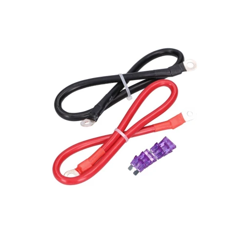 Na zdjęciu znajdują się dwa kable z oczkami na końcach, jeden czarny i jeden czerwony, ułożone w kształt pętli. Obok kabli leżą dwa fioletowe bezpieczniki.