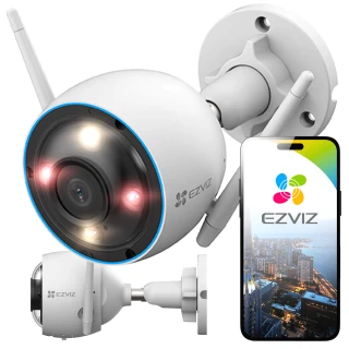 Bezprzewodowa kamera WiFi EZVIZ z widocznymi diodami LED i antenami, zamontowana na ścianie. Obok kamery znajduje się smartfon z aplikacją EZVIZ pokazującą widok z kamery.