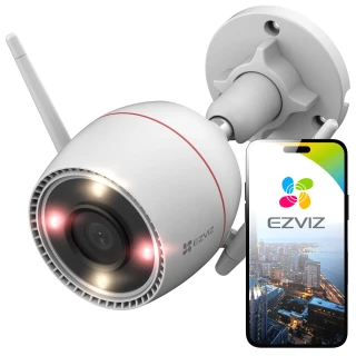 Bezprzewodowa kamera WiFi EZVIZ z widoczną anteną i obiektywem, zamontowana na ścianie. Obok kamery znajduje się smartfon z aplikacją EZVIZ pokazującą widok z kamery.