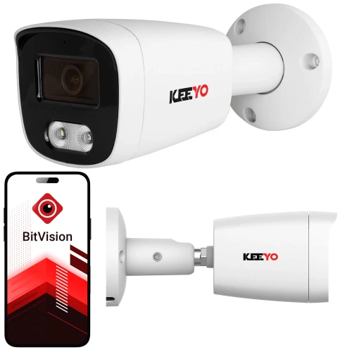 Biała kamera tubowa IP marki Keeyo jest zamontowana na ścianie, z widocznym logo na obudowie. Obok kamery znajduje się smartfon z aplikacją BitVision, prezentującą interfejs użytkownika.