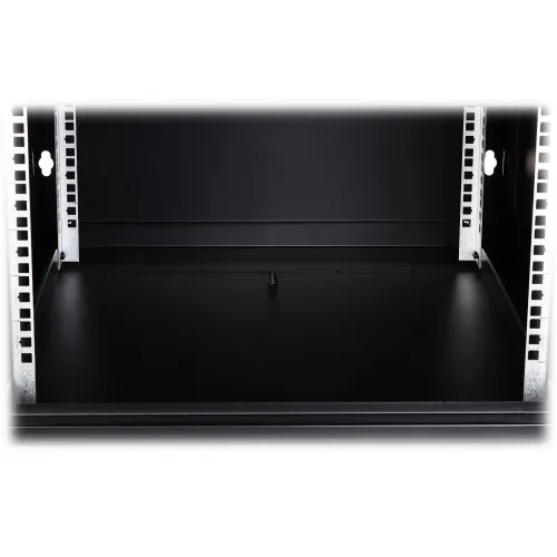 Zdjęcie przedstawia wnętrze czarnej szafy serwerowej z widocznym przepustem kablowym w podłodze. Wnętrze jest puste, a przepust znajduje się centralnie na dolnej powierzchni.