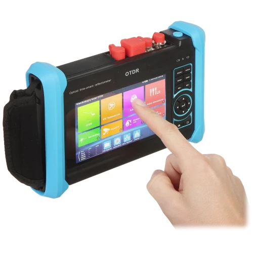 Osoba obsługuje przenośne urządzenie OTDR z kolorowym ekranem dotykowym, które jest zabezpieczone niebieską obudową ochronną. Na ekranie widoczne są różne kolorowe ikony aplikacji i funkcji.