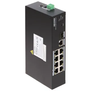 Na zdjęciu znajduje się czarny, prostokątny switch PoE marki Hikvision z ośmioma portami i jednym portem SFP. Urządzenie ma zielone złącze na górze i etykietę z informacjami technicznymi z boku.