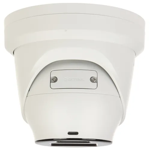 Biała kamera kopułkowa z widocznymi śrubami montażowymi i napisem "SETTING" na bocznej części obudowy. Kamera ma nowoczesny, minimalistyczny design i jest skierowana w dół.