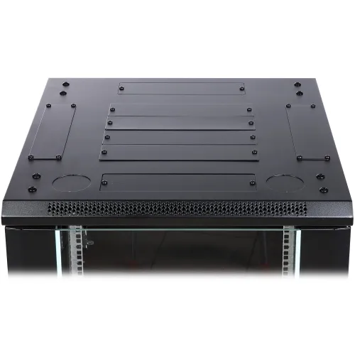 Czarny panel z otworami montażowymi i kratką wentylacyjną na górze. Widoczne są również szklane drzwi z metalowymi ramkami po bokach.