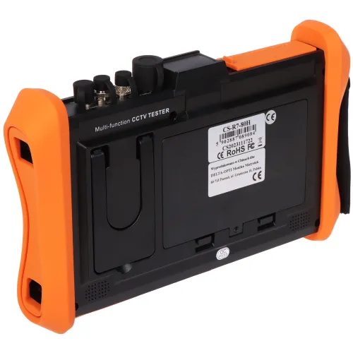 Na zdjęciu znajduje się wielofunkcyjny tester CCTV z widocznymi złączami i etykietą z tyłu urządzenia. Obudowa testera jest czarna z pomarańczowymi uchwytami po bokach.