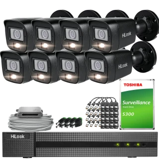 Zestaw do monitoringu składający się z sześciu czarnych kamer HiLook, rejestratora oraz dysku twardego Toshiba S300. W zestawie znajdują się również kable i akcesoria montażowe.