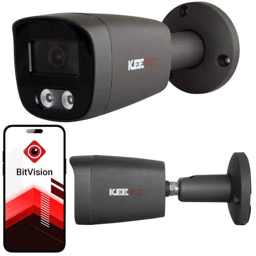 Na zdjęciu znajduje się czarna kamera monitoringu marki KEEYO zamontowana na ścianie oraz aplikacja BitVision pokazana na ekranie smartfona. Kamera ma cylindryczny kształt i jest wyposażona w dwa diody LED.