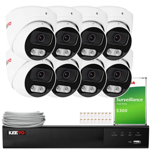 Na zdjęciu znajduje się zestaw do monitoringu IP, który obejmuje osiem białych kamer, rejestrator oraz dysk twardy Toshiba S300. Obok rejestratora widoczny jest również kabel i zestaw złączek.