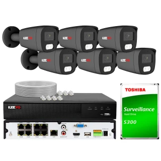 Na zdjęciu znajduje się zestaw do monitoringu, który obejmuje sześć kamer, rejestrator oraz dysk twardy Toshiba S300. W tle widoczne są również akcesoria, takie jak kable i złącza.