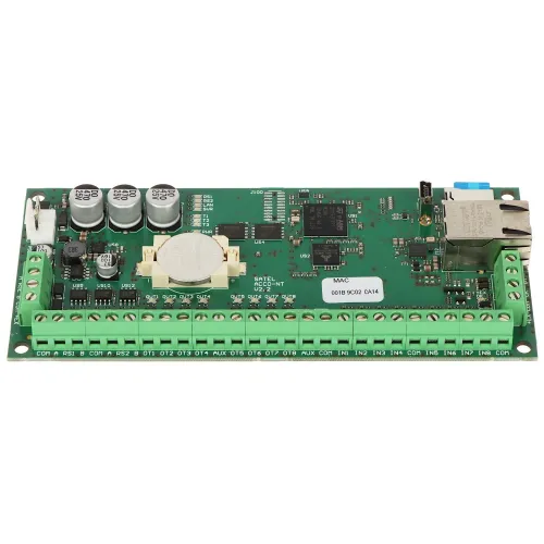 Zdjęcie przedstawia zieloną płytkę drukowaną z różnymi komponentami elektronicznymi, w tym kondensatorami, złączami i portem Ethernet. Na dole płytki znajdują się zielone złącza śrubowe oznaczone różnymi etykietami.